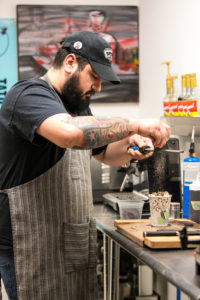 Monroe Payne tops off “The Siouxsie” with Mexican chocolate for a to-go order on January 25, 2018. Photo by Stephanie Marquez.